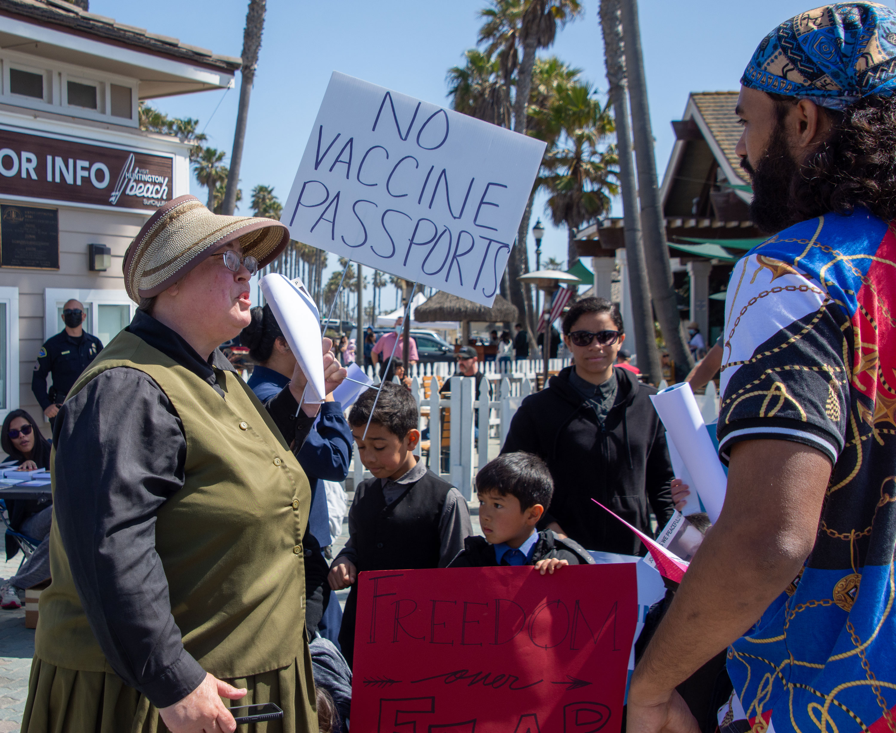 Protesters discuss their platforms at the Huntington Beach Freedom Rally on March 20, 2021.