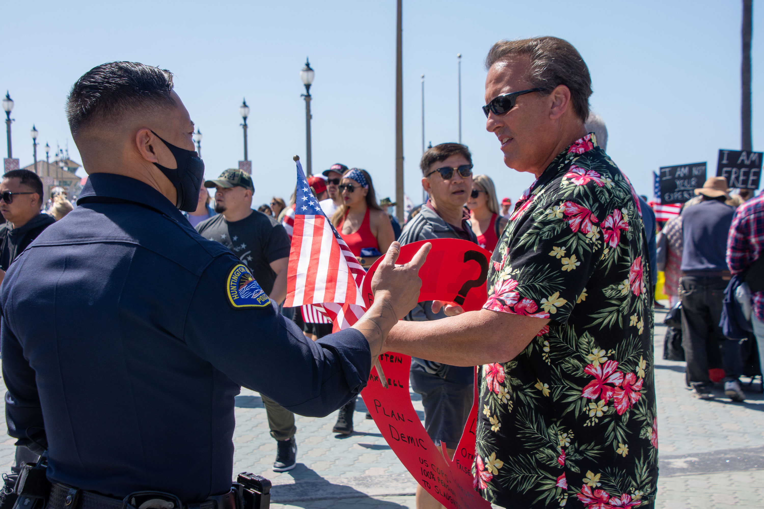 Huntington Beach police officer explains protest rules to anti-vaccine protester.